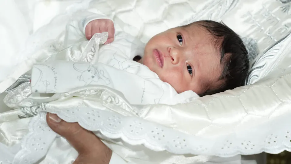 baby Michael in white clothes and blanket