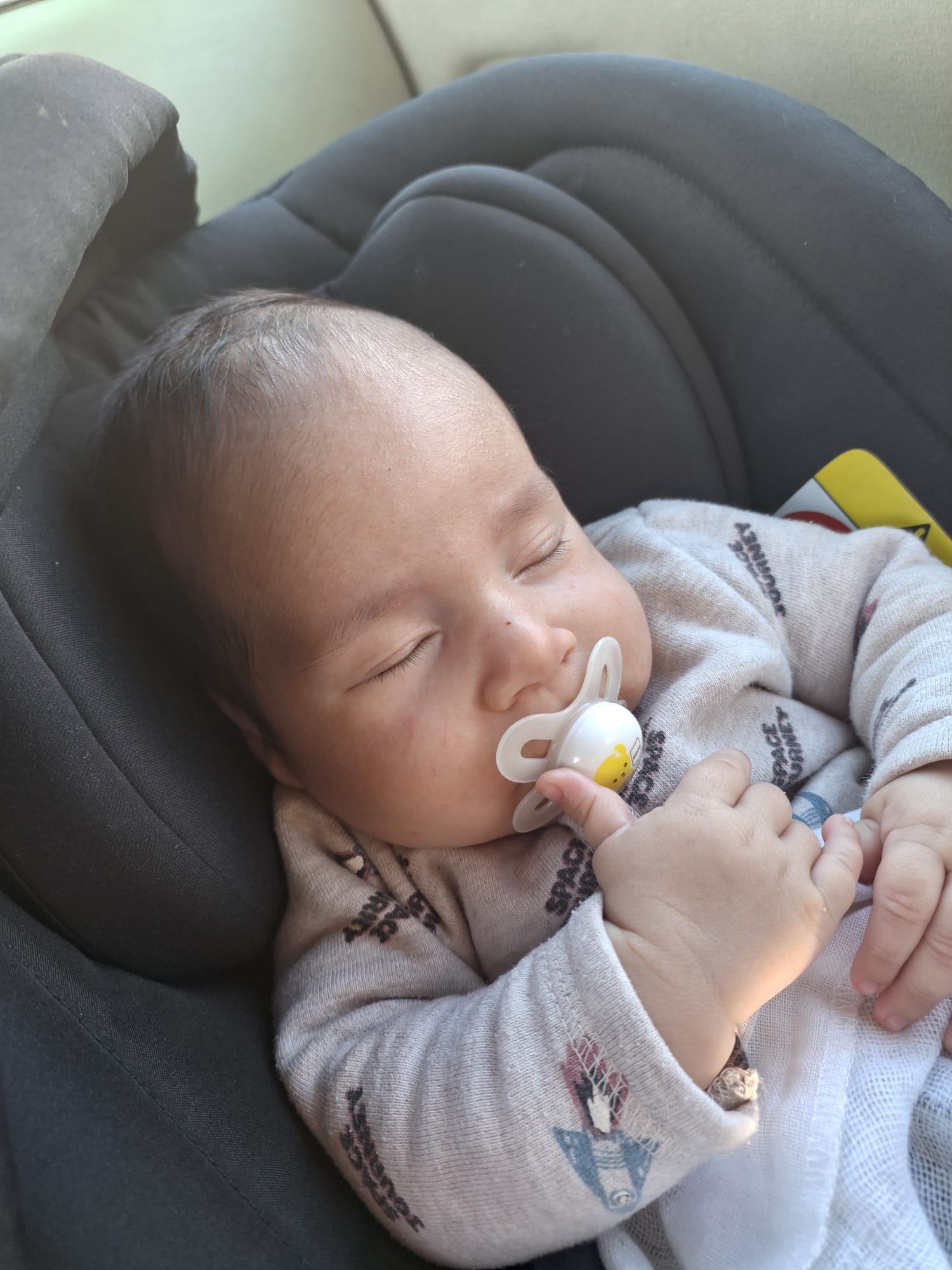 Hadar Meir sleeping with pacifier in a car seat