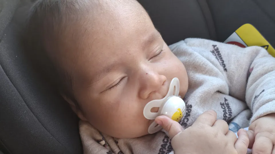 Hadar Meir sleeping with pacifier in a car seat