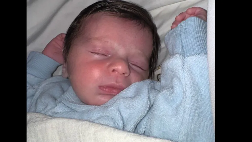 baby Imri David in light blue sweater, sleeping peacefully