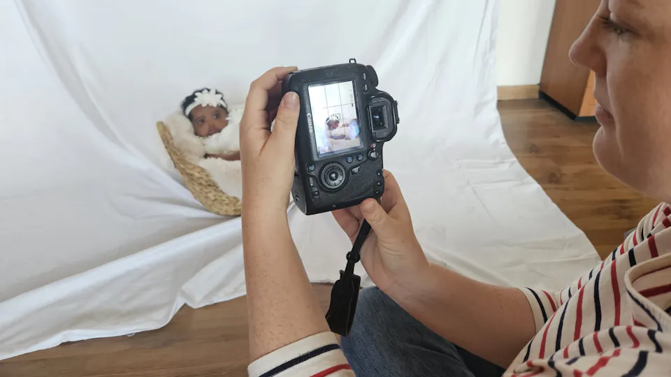 seeing the photographed baby through the camera of the photographer
