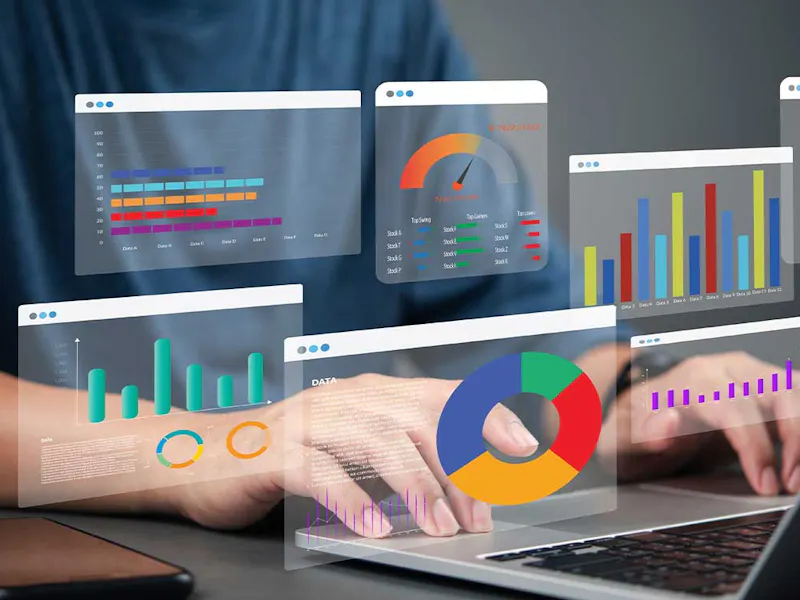 Graphs reflecting business financial metrics coming out of a laptop screen.