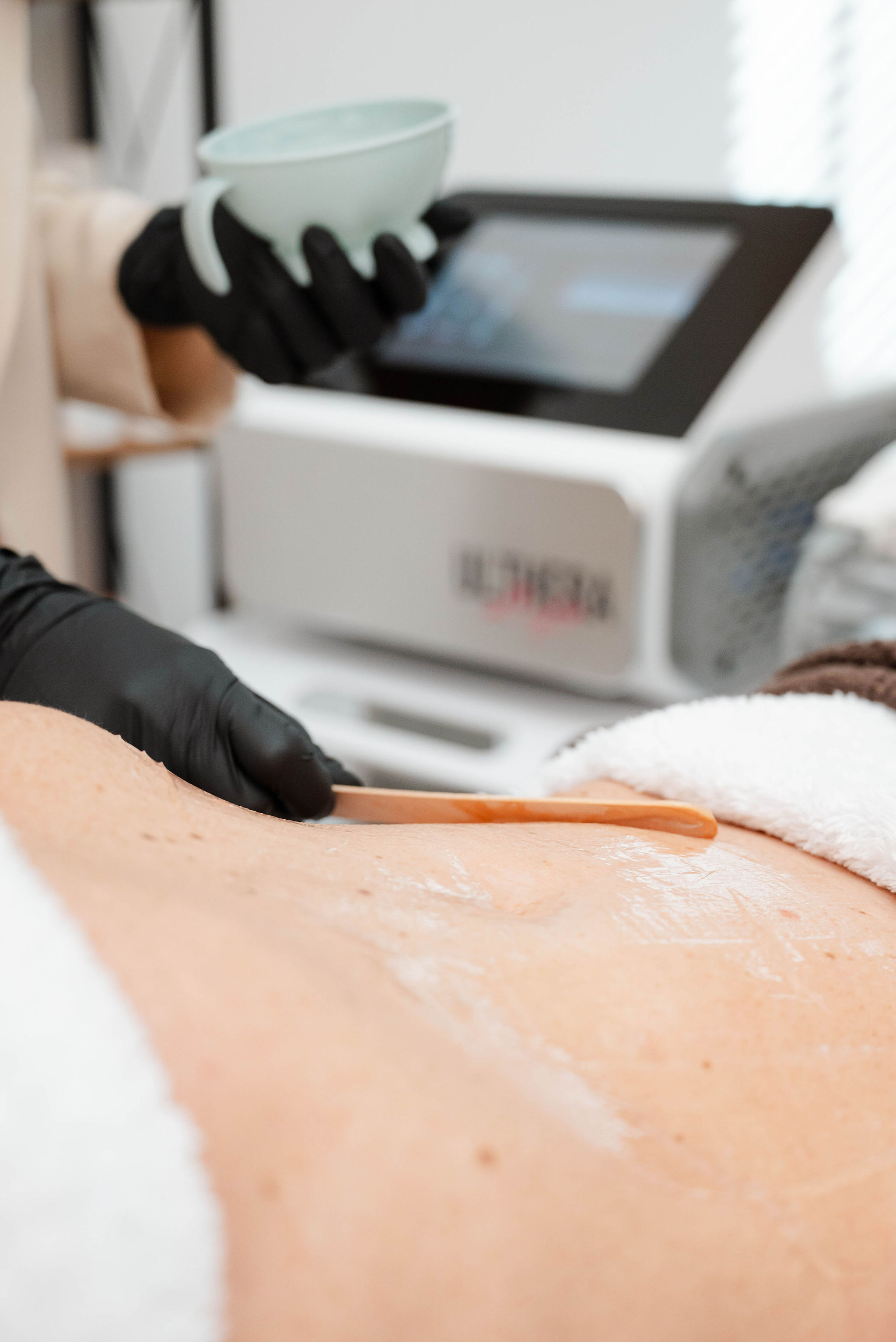 Schoonheidsspecialiste voert een professionele bodybehandeling uit met een geavanceerd huidverzorgingsapparaat. Perfect voor huidversteviging en contouring.
