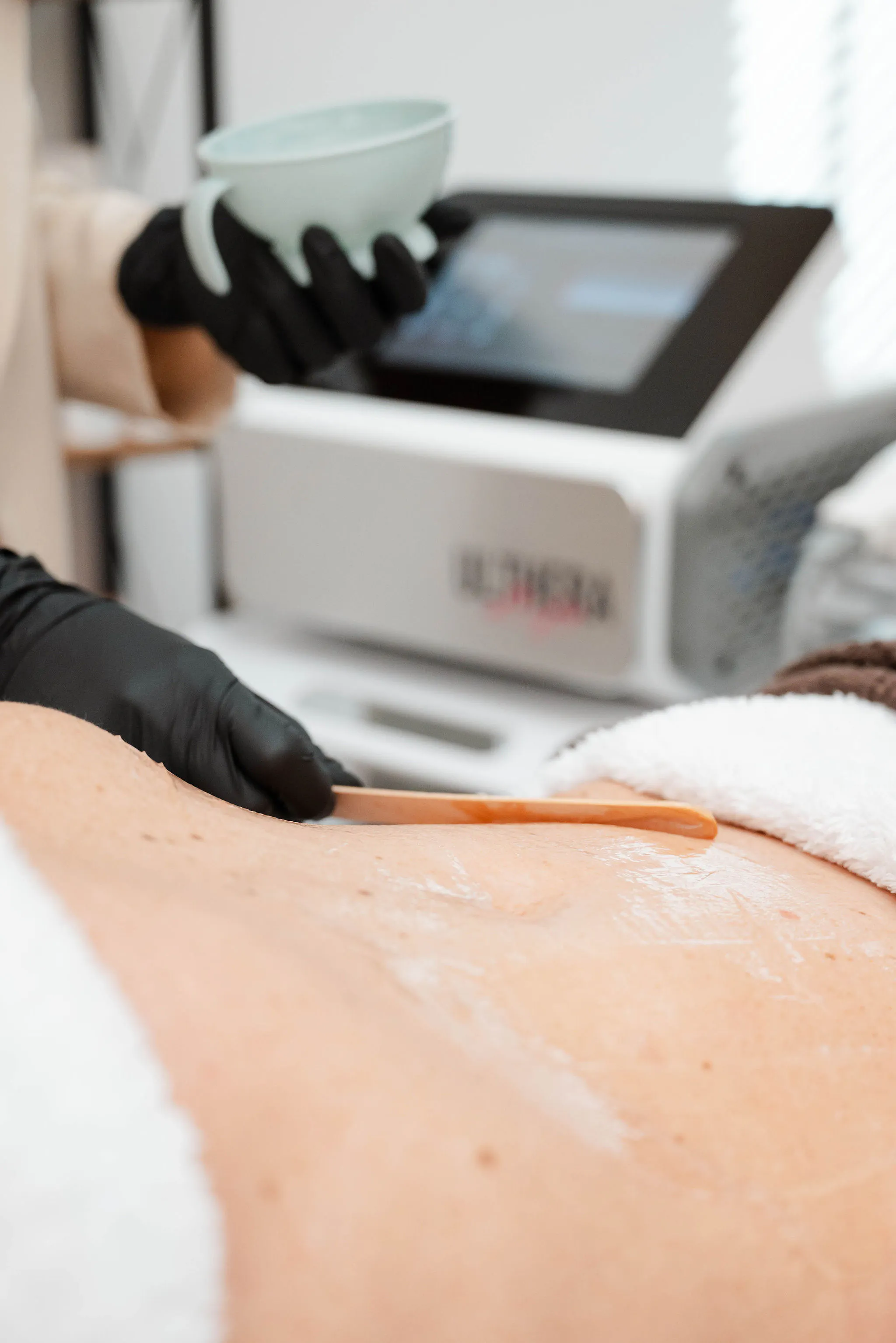 Schoonheidsspecialiste voert een professionele bodybehandeling uit met een geavanceerd huidverzorgingsapparaat. Perfect voor huidversteviging en contouring.