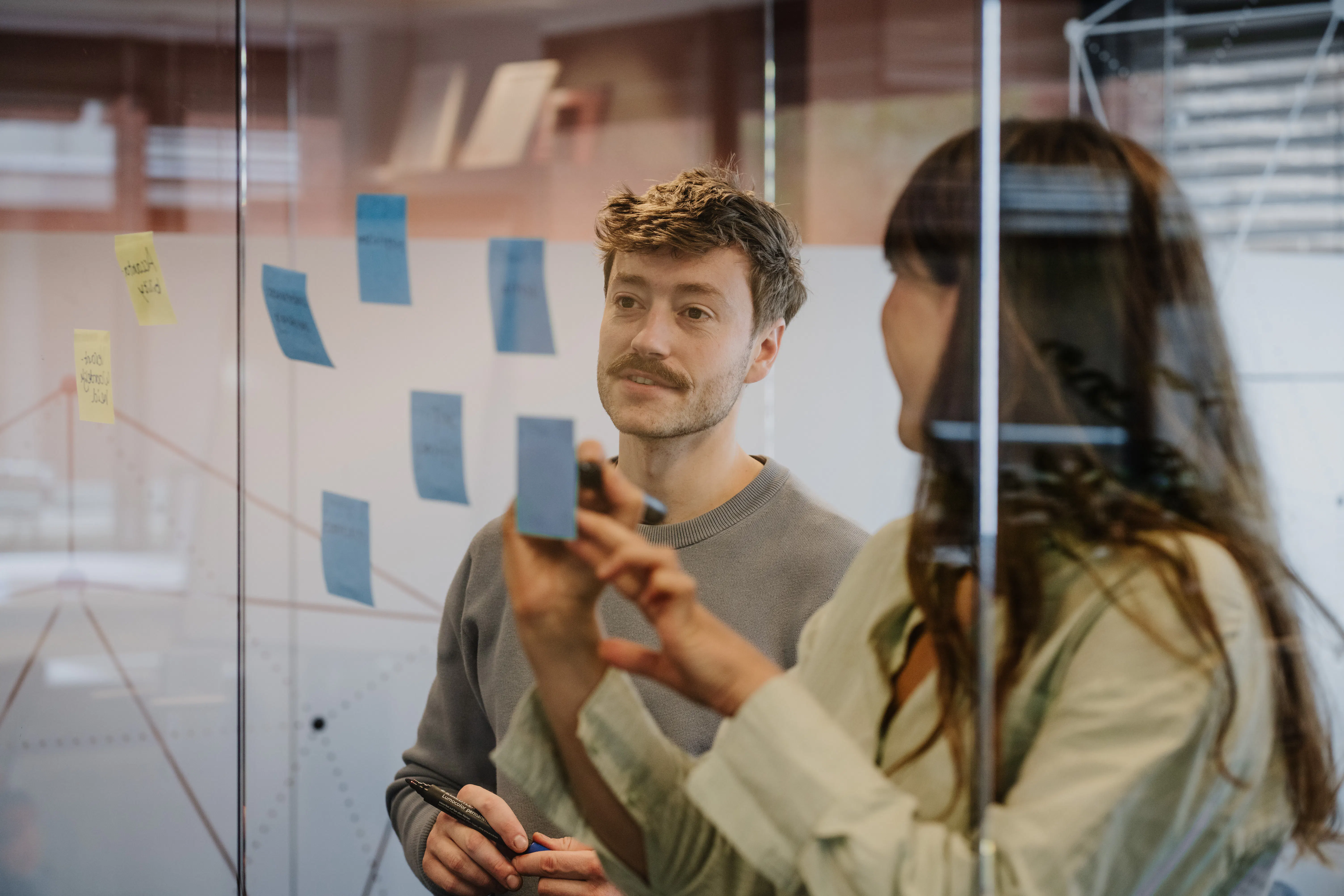 Twee adviseurs brengen de contactmomenten in kaart op post-its.