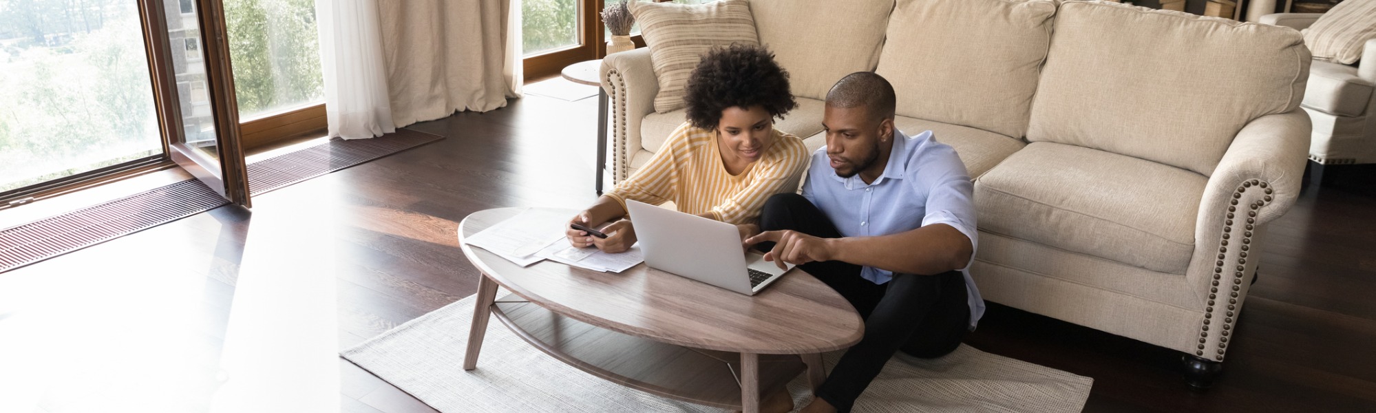 A couple working on a laptop to calculate how much rent to charge for an investment property