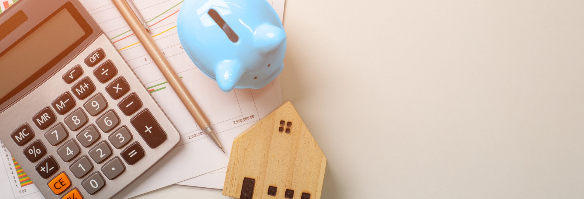Qualified Business Income Deductions for landlords, depicted with a calculator, a blue piggy bank and a wooden home.