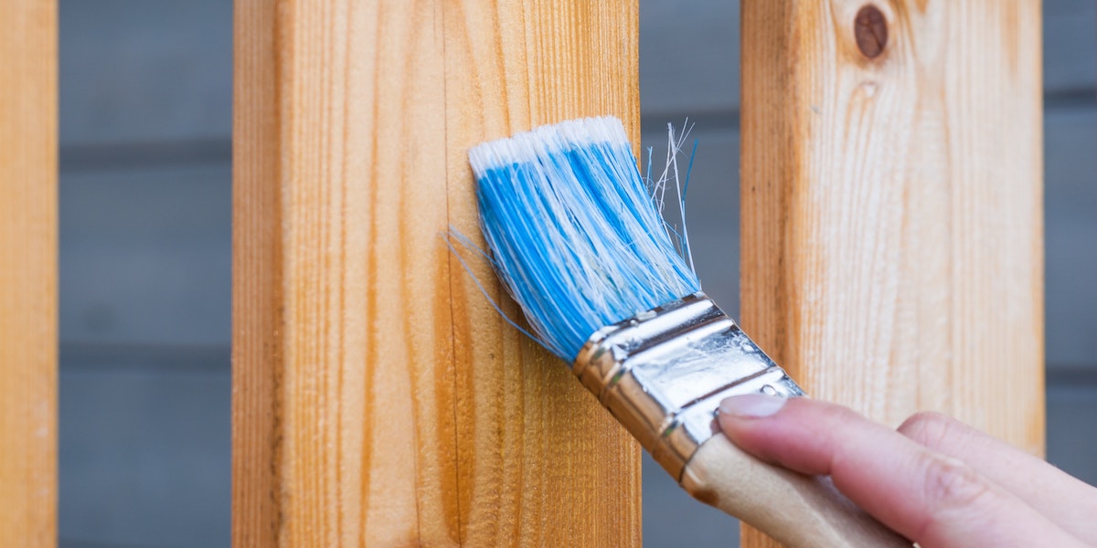 An image of a fence being varnished, one of the things you can do to prepare your property for the rental market
