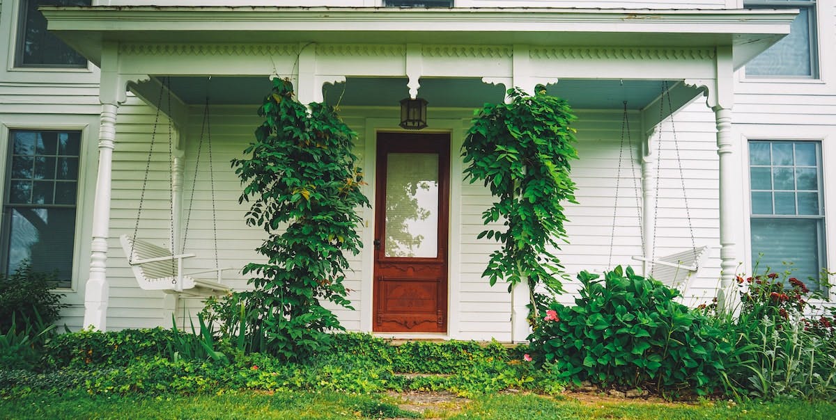 The front of a home with the garden growing long and in need of pruning - one of the annual maintenance items to check off to maintain a rental home in California