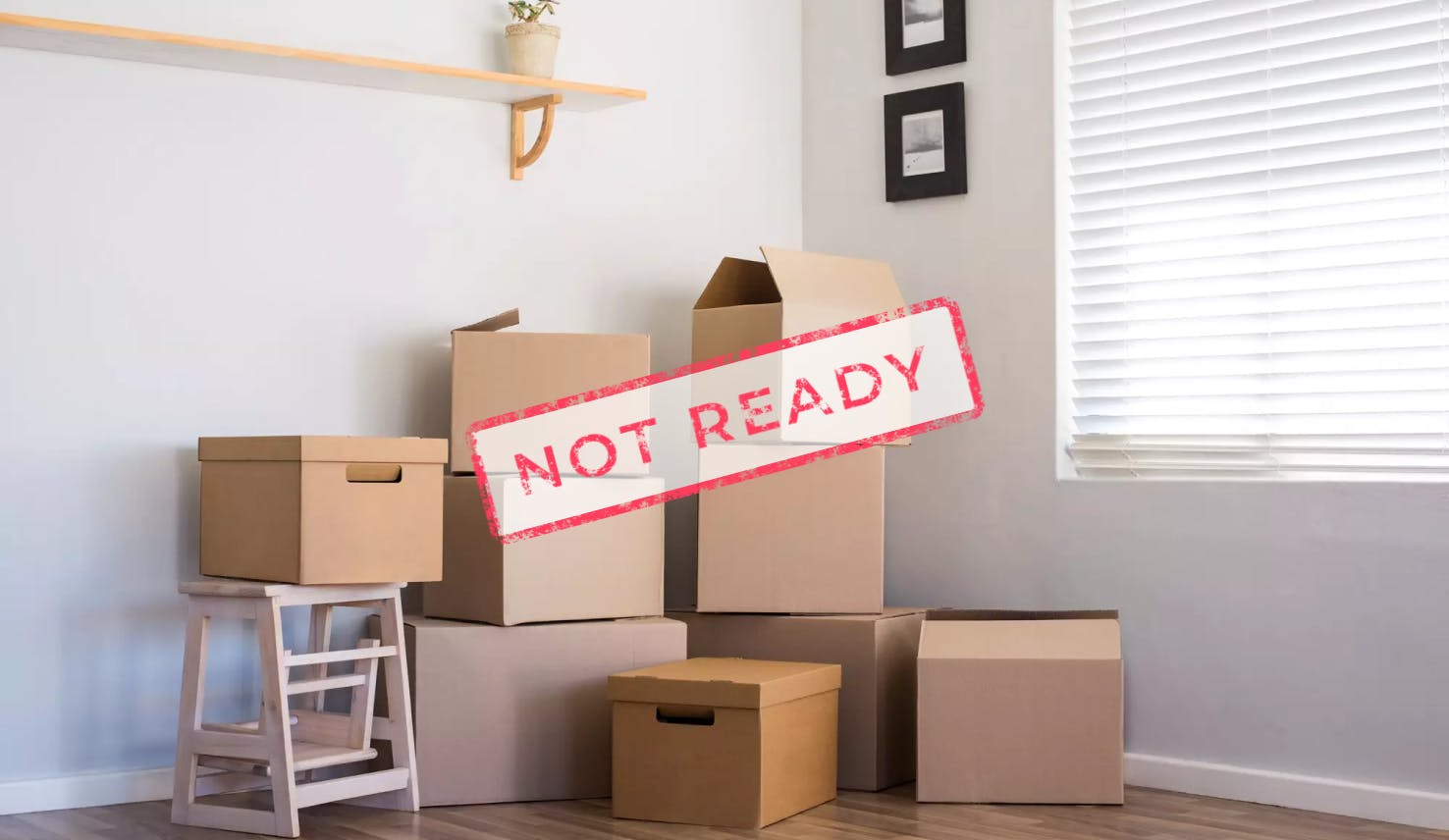 An image of moving boxes and photo frames in the corner of a house, labeled "NOT READY" as this would not suffice for a rental inspection to put your home on the market