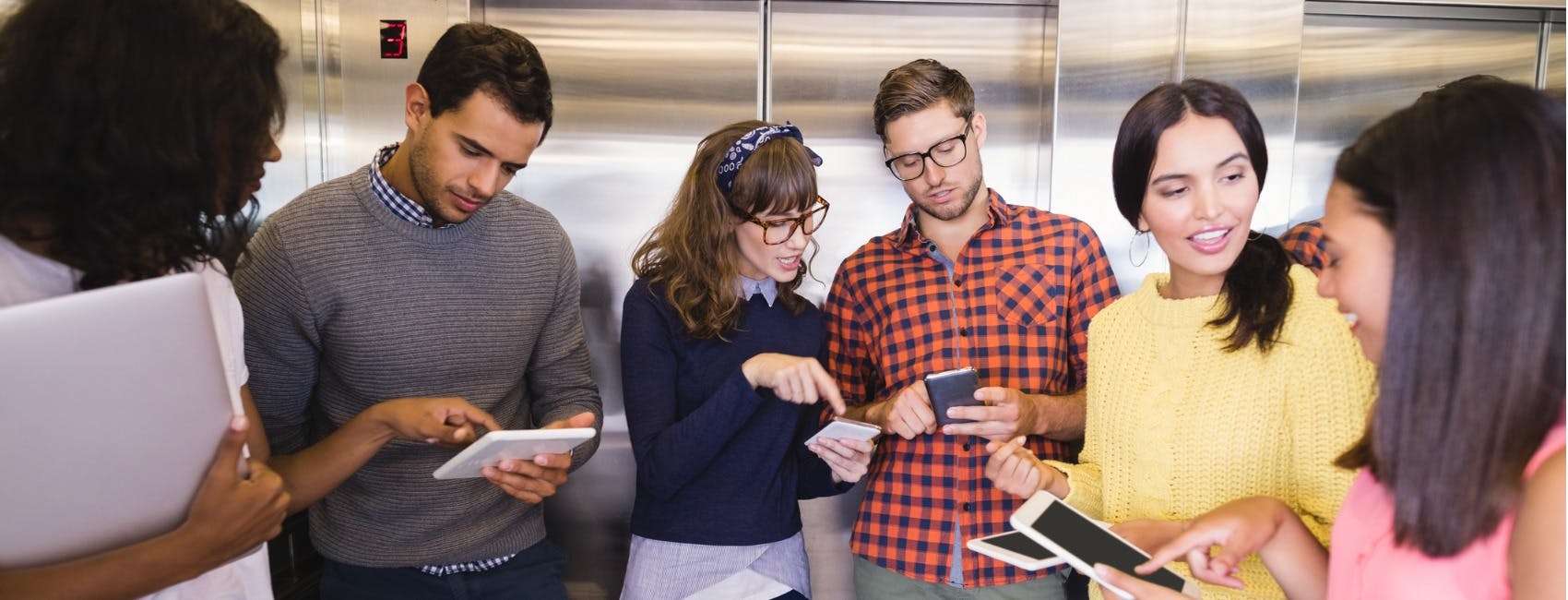 Group of people looking at devices, comparing notes and discussing personality quiz for property management