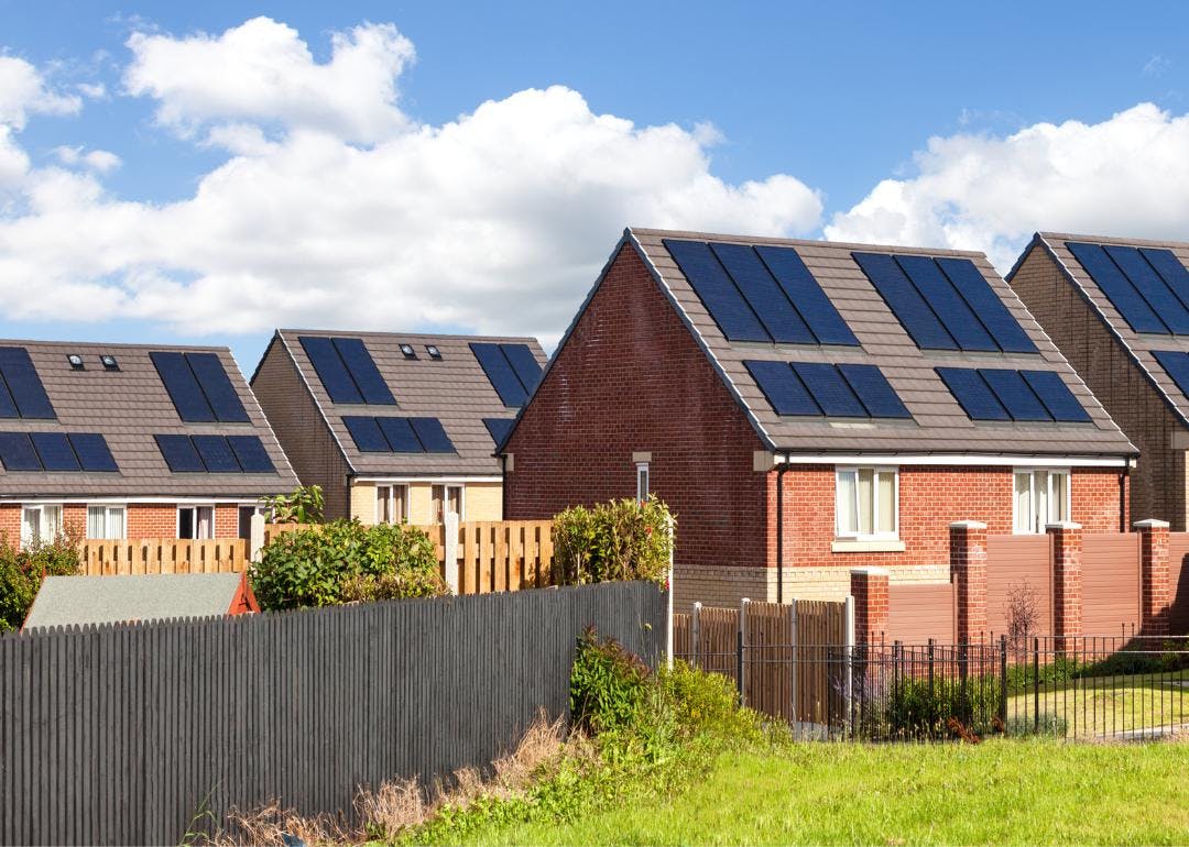 A photo depicting a row of energy-efficient homes with solar panels on the roof