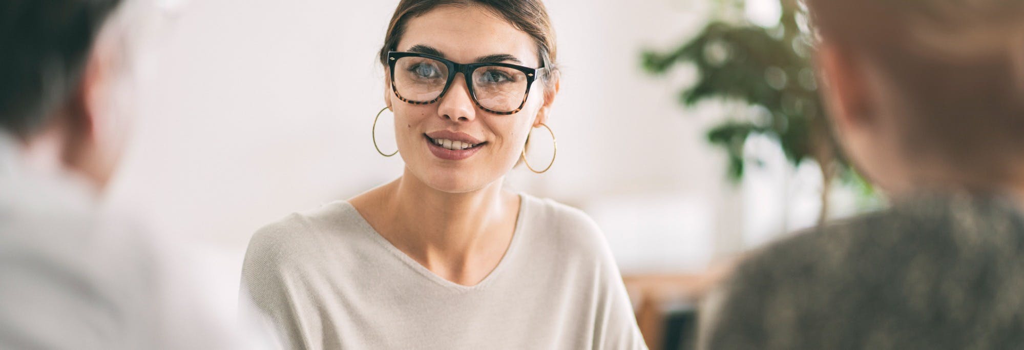 Young woman wearing glasses, landlord speaking to her rental tenants