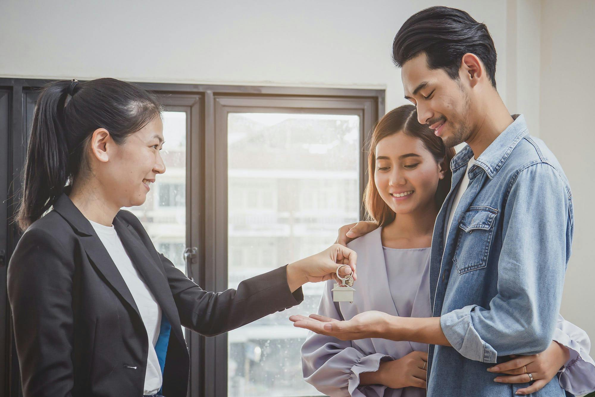 Property manager handing keys to a rental to happy couple