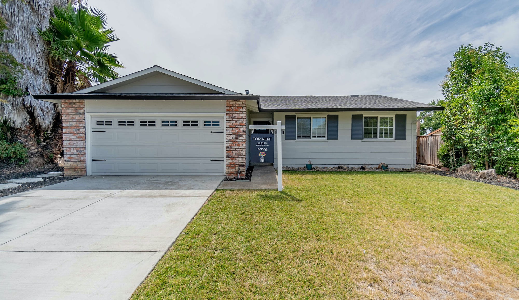 A single family rental home in America with a sign in the front yard 