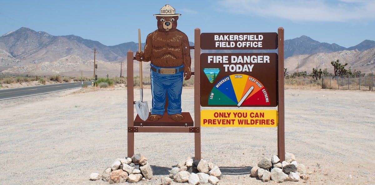 A photo of Smokey Bear Fire Danger Sign in Bakersfield, California. Learn more about investing in or owning a rental property in a fire zone.