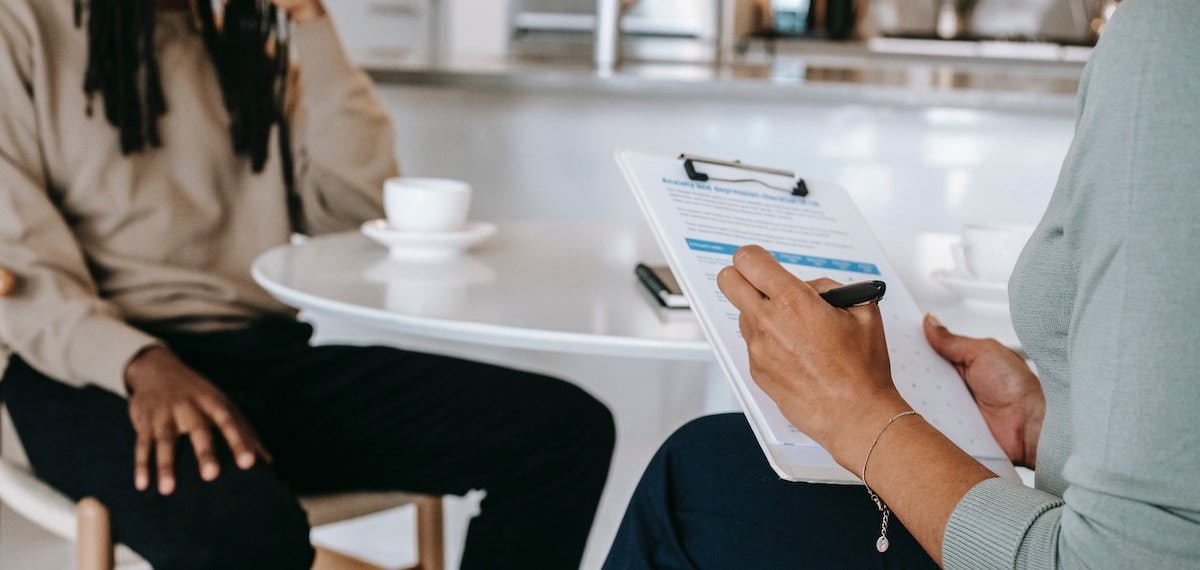 Two people at a kitchen table, using a checklist to calculate prorated rent to maintain a positive cash flow between leases. 