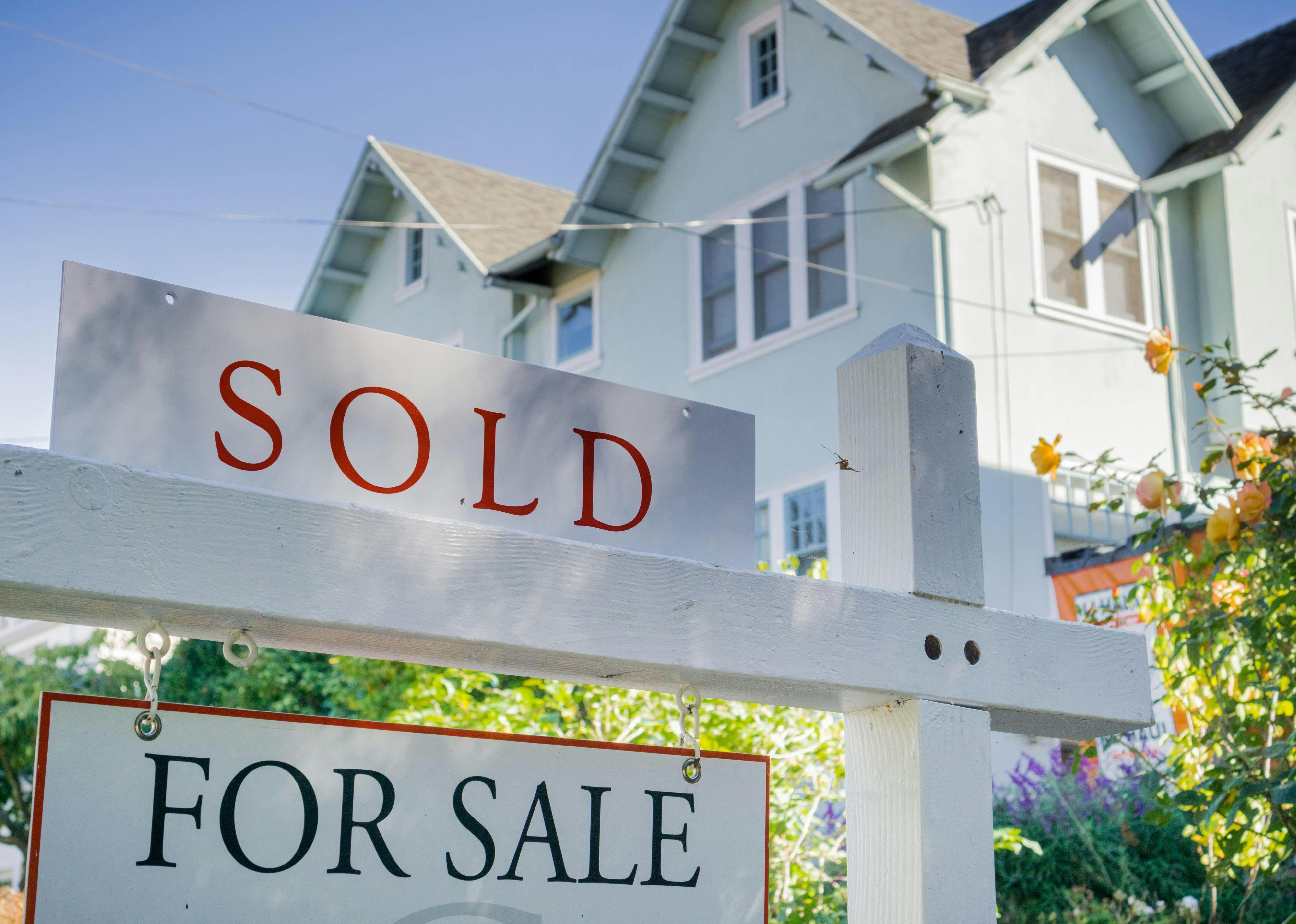 image showing a sold & for sale sign in front of prime real estate