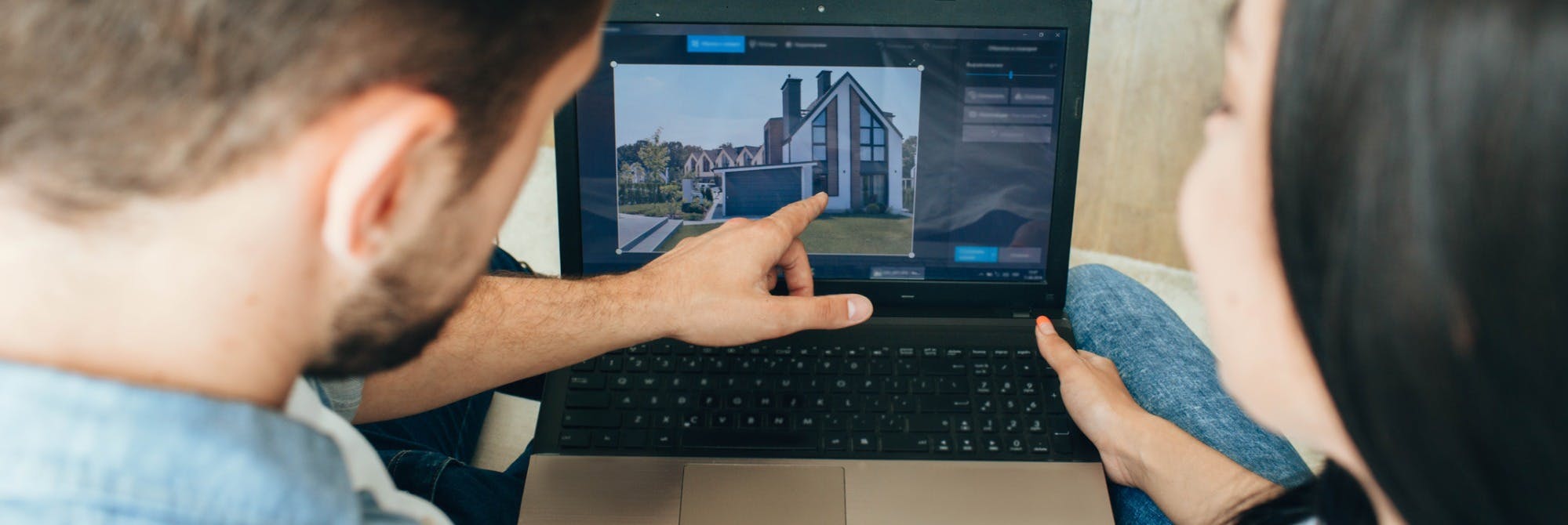 A Belong staff member planning how to manage a rental home, pointing to an image on a laptop