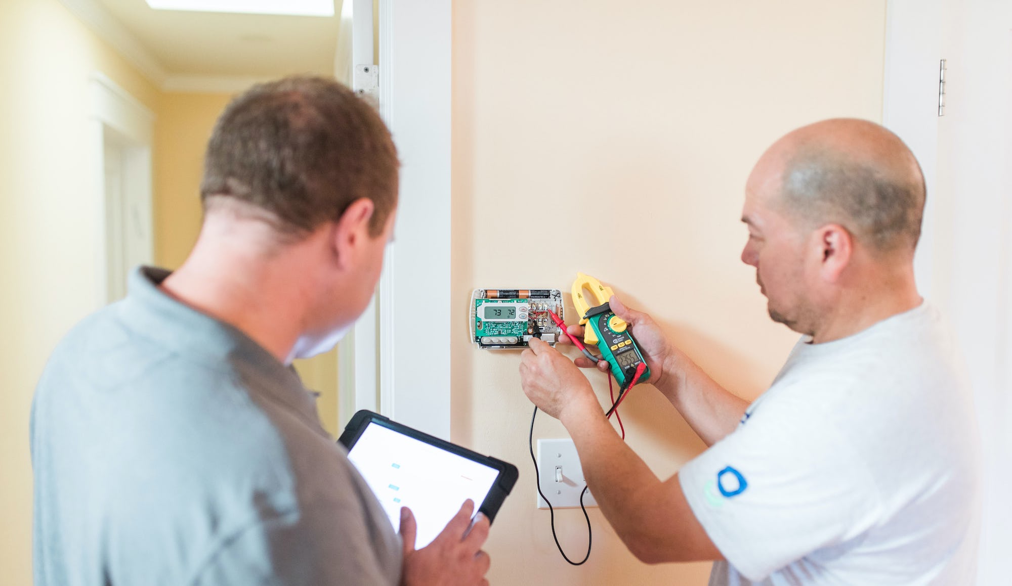 Two trademen work on a rental home to conduct repairs and maintenance