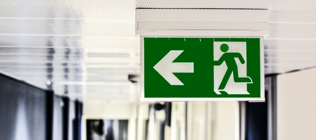 A photo of a green emergency exit sign in a hallway