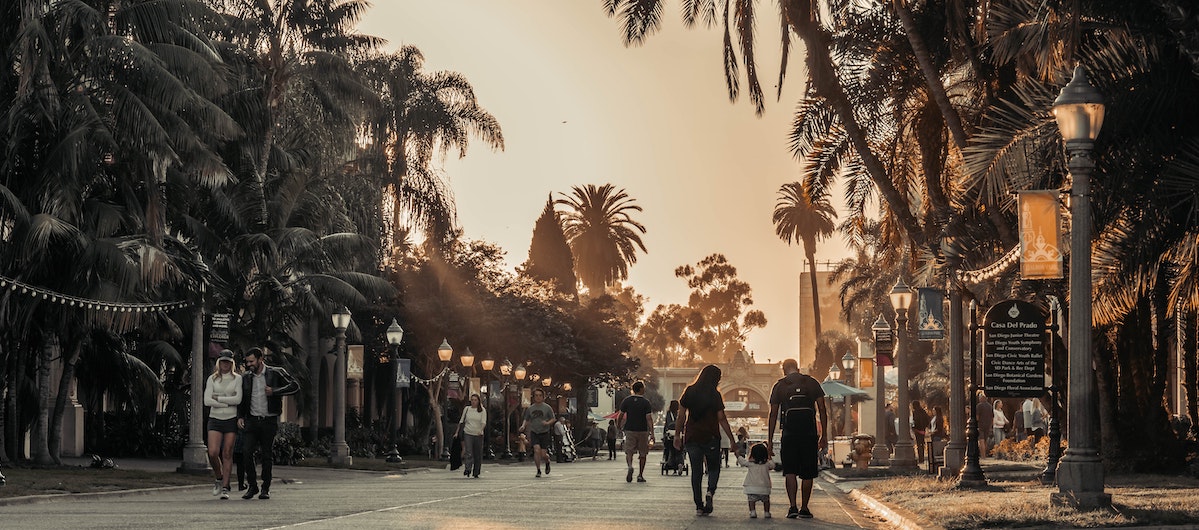 A young family take an evening stroll through San Diego on vacation. Learn more about San Diego's new caps and regulations on short-term vacation rentals.