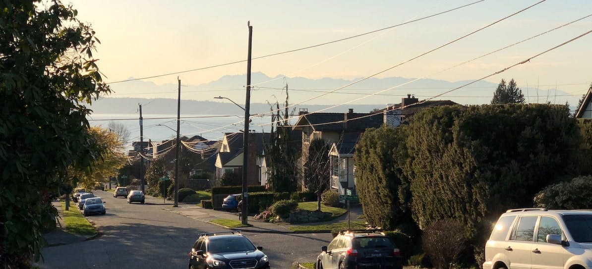 A photograph of Sunset Hill, Seattle depicting a suburban street with homes and cars
