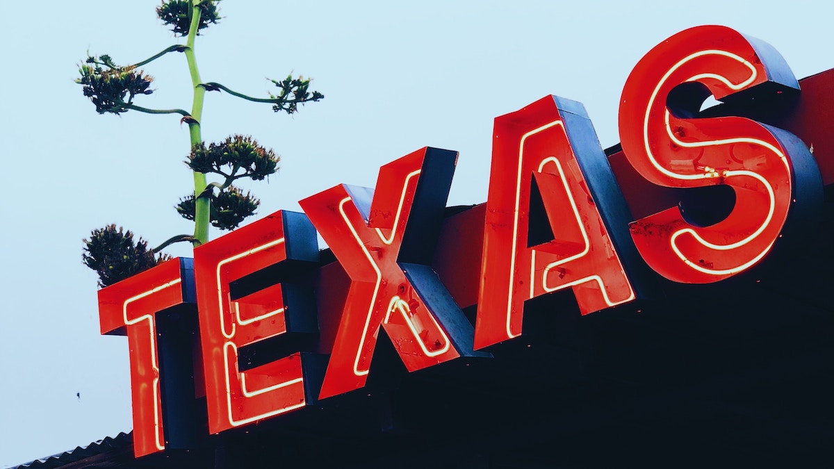 A large red neon sign reads "TEXAS" in capital letters. Texas is the latest state to join the Belong network for rental homes in Austin, Dallas/Fort Worth, Houston and San Antonio. 