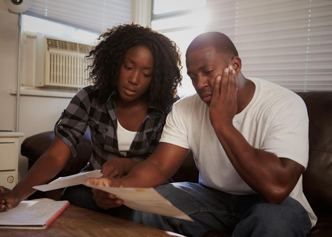 distressed couple looking at increasing rent bills together