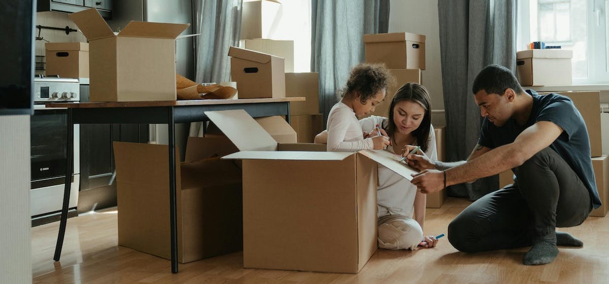 A family of 3 prepare to move home with packing boxes