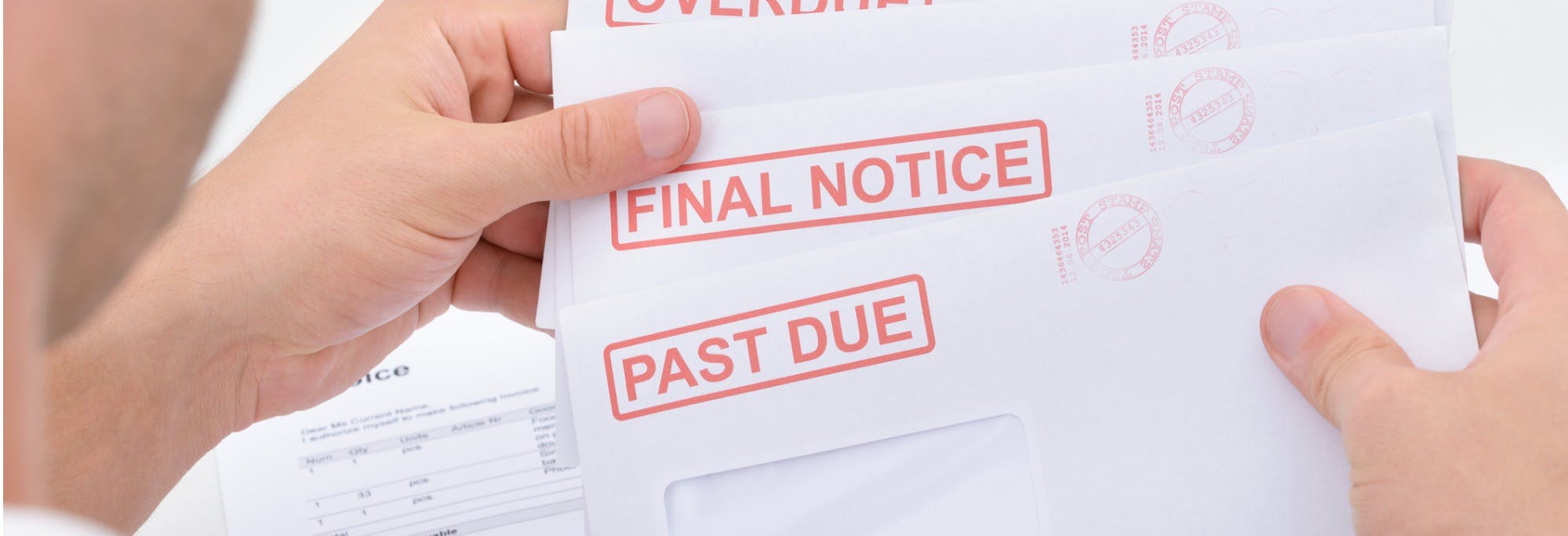 Person holding a stack of envelopes marked "final notice" and "past due", overdue in rental payments