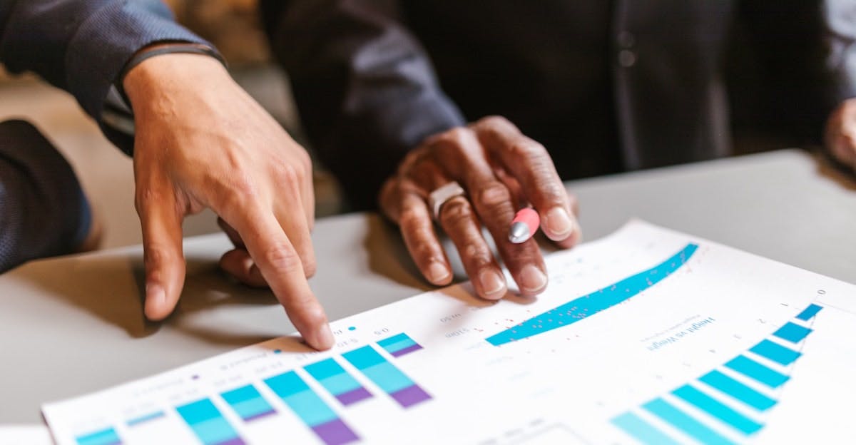 Image shows the different hands of two people looking over figures, exploring options for an investment property that is negative cashflow