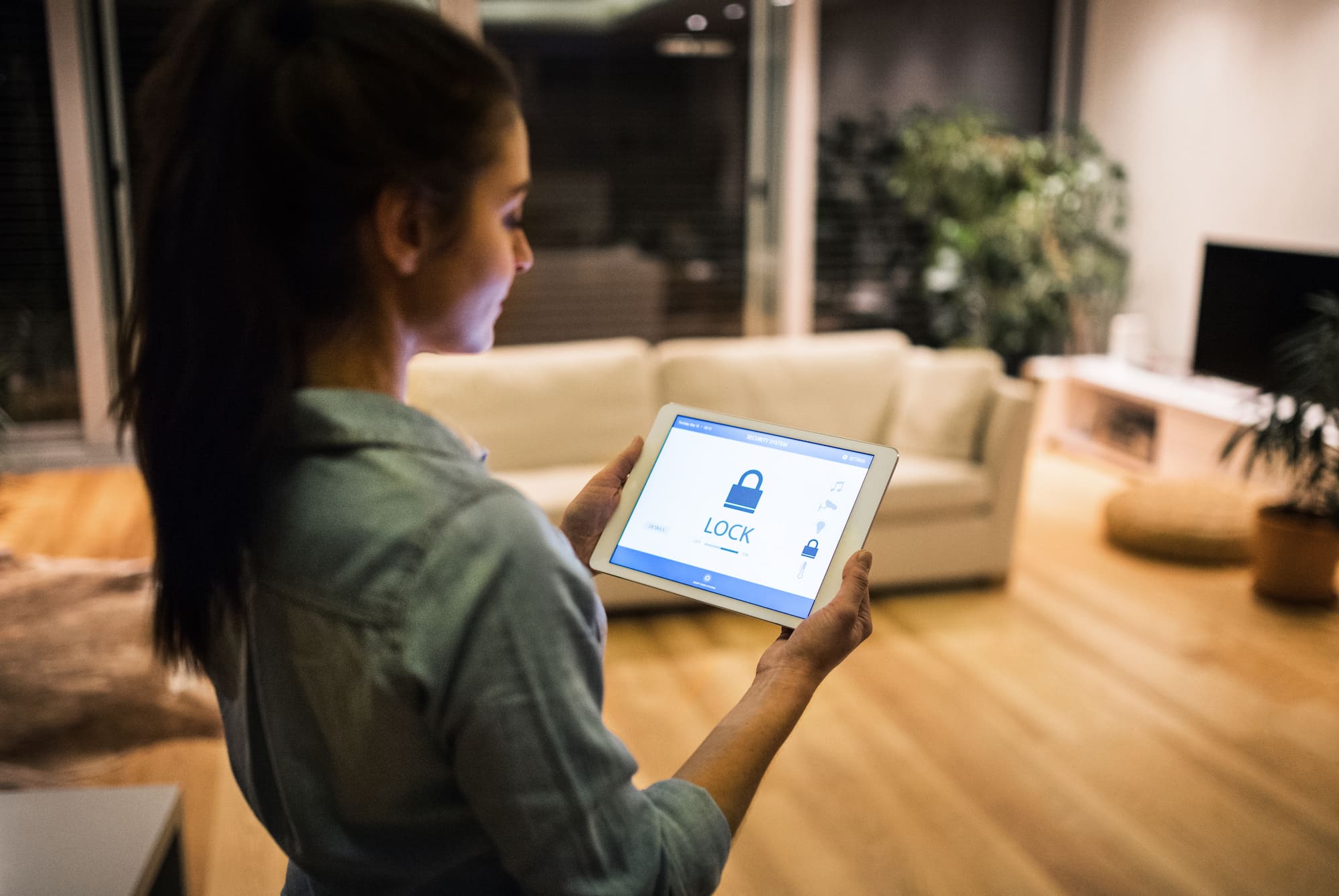 A renter checks her home security system on a tablet