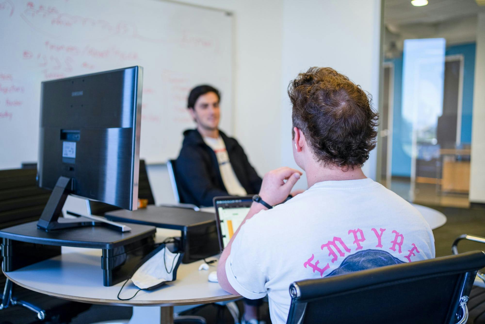 Two staff members who work at Belong have a meeting in their office