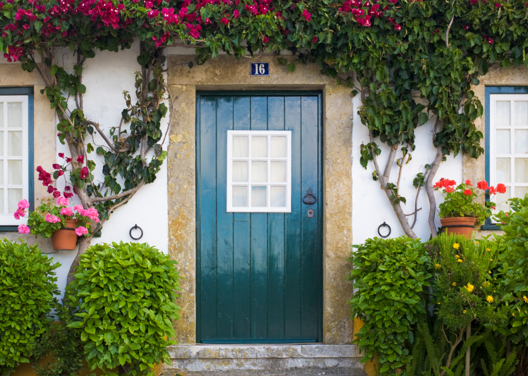 a beautiful home entrance with a blue door and flowers