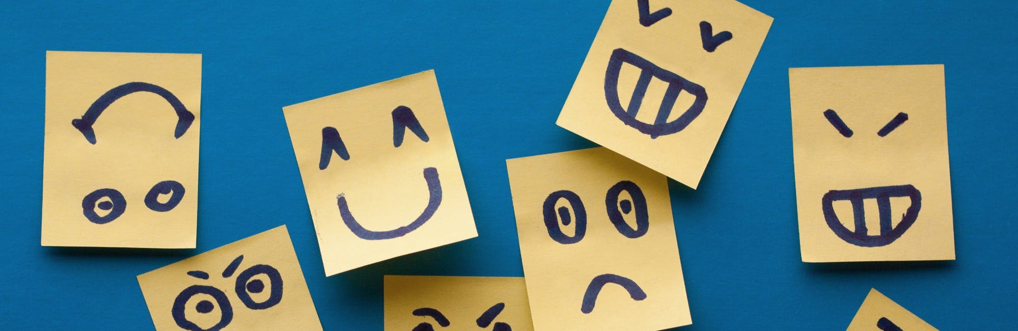 A series of sticky-notes with happy, sad, and angry faces drawn on, conveying a change in mindset