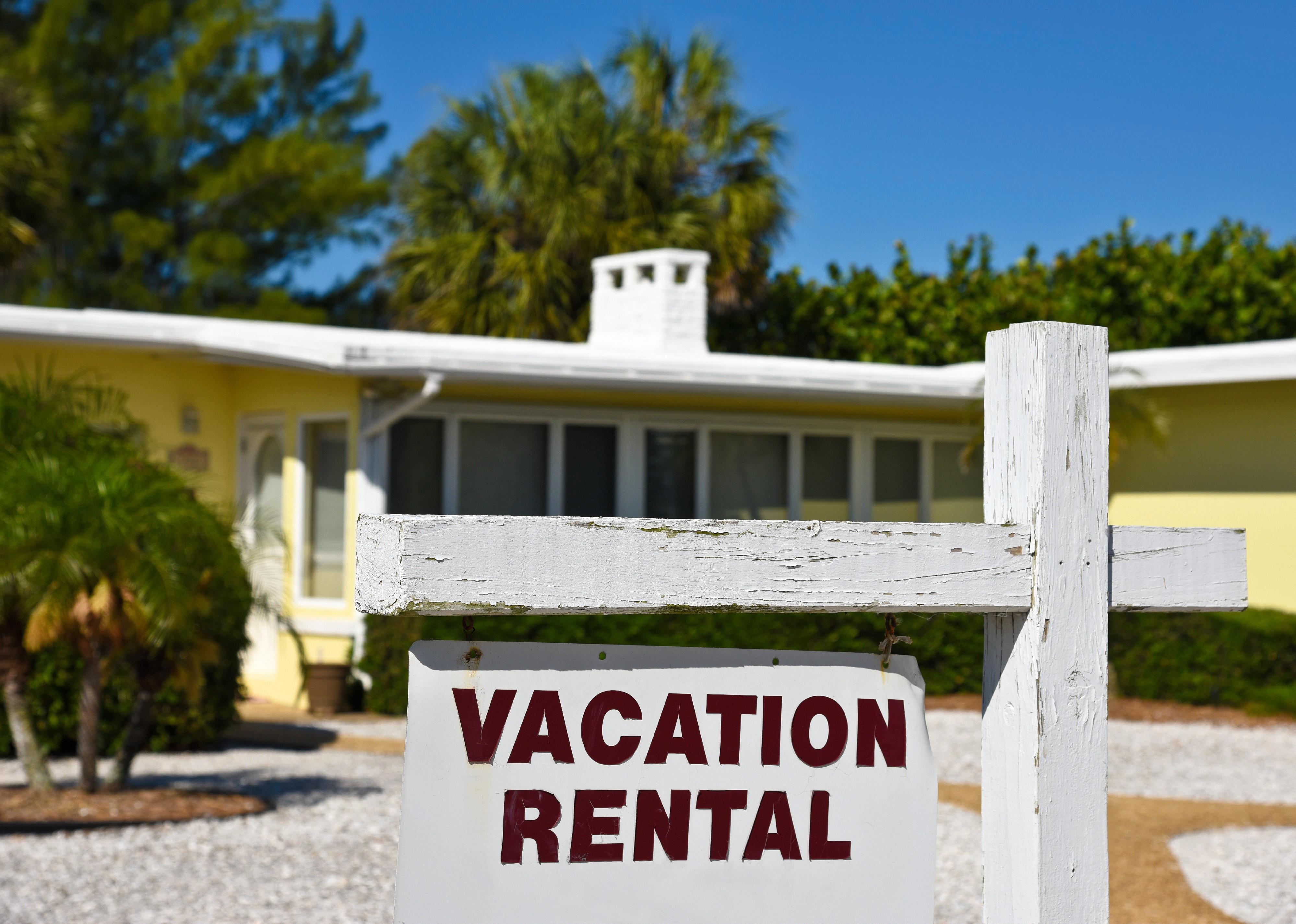 An old home with a signpost that reads "vacation rental"