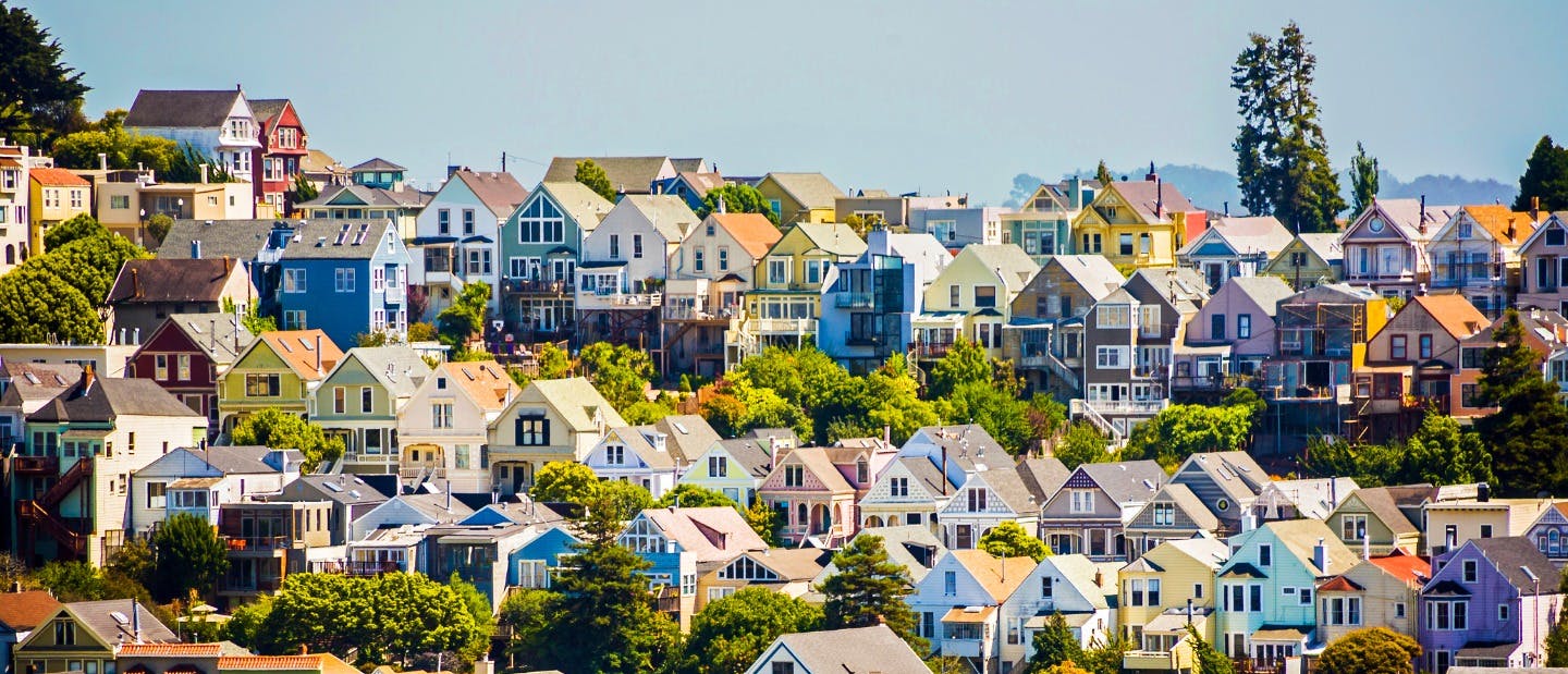 Multiple rows of homes with mountains and sky in the background 