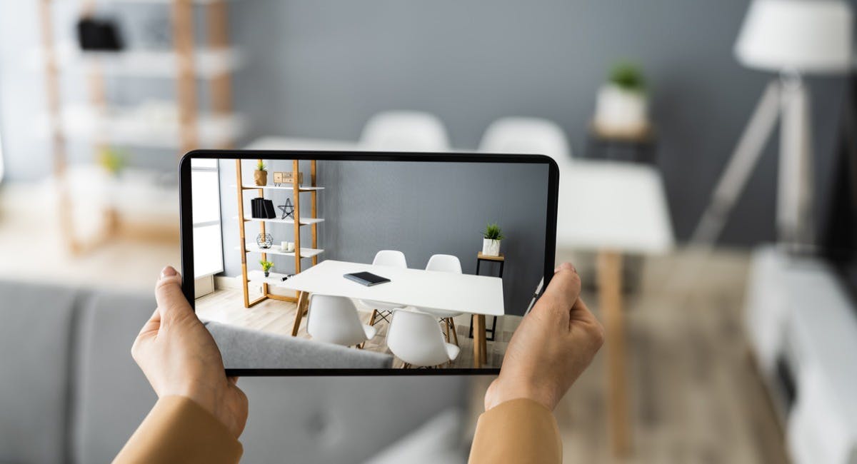 Two hands hold up a smart tablet to film a virtual open home to promote a rental property 