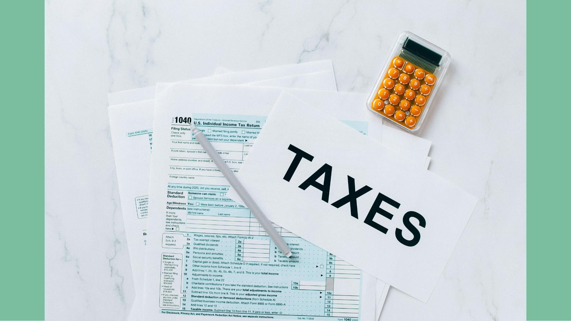 A flatlay image of taxation paperwork and a calculator with a sign that reads "TAXES", depicting tax season for landlords