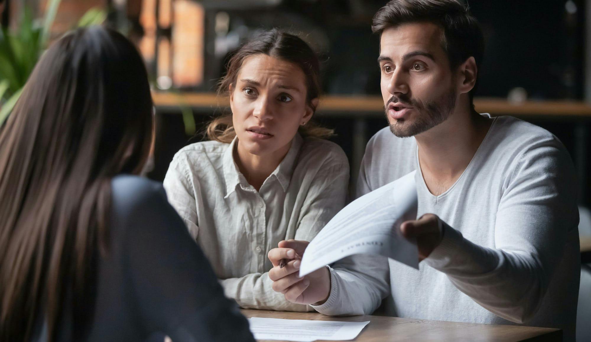 Frustrated couple discussing paperwork with their property manager