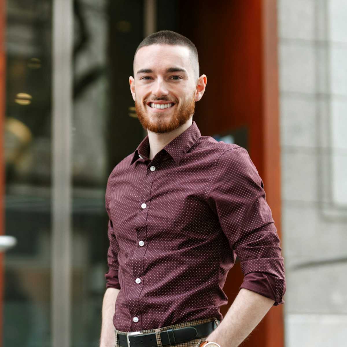 A man wearing a purple shirt standing in the street.
