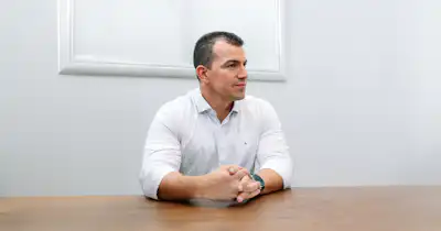 Man in an office setting sitting down.