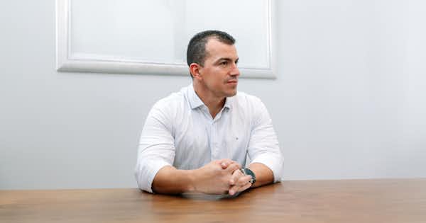 Man in an office setting sitting down.