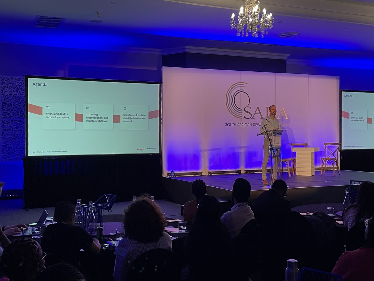 Person giving a keynote presentation at a conference.