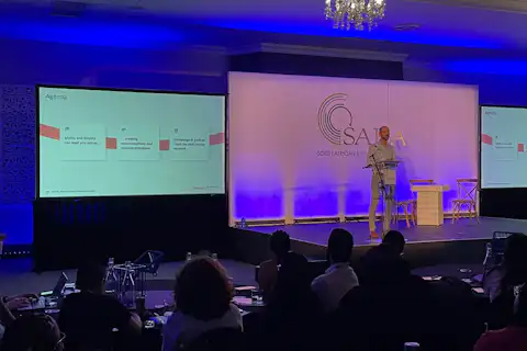Person giving a keynote presentation at a conference.