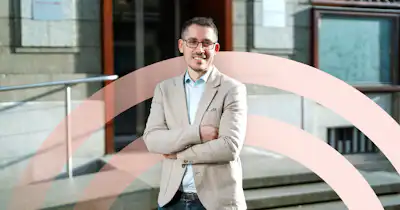 Employé heureux avec les bras croisés devant le bureau.