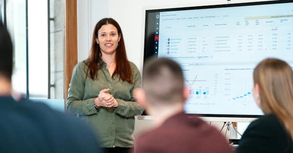 Woman presenting to a group from a projected computer screen