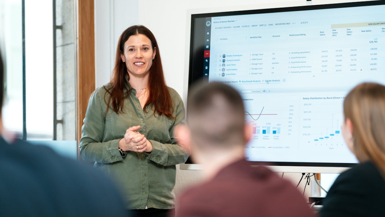 Woman presenting to a group from a projected computer screen