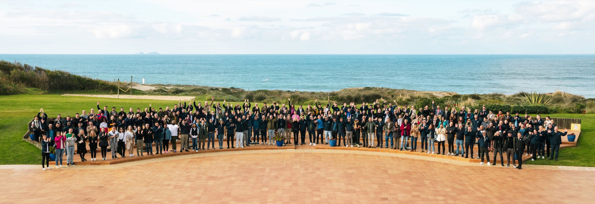 A group photo of beqom employees standing by a pool.